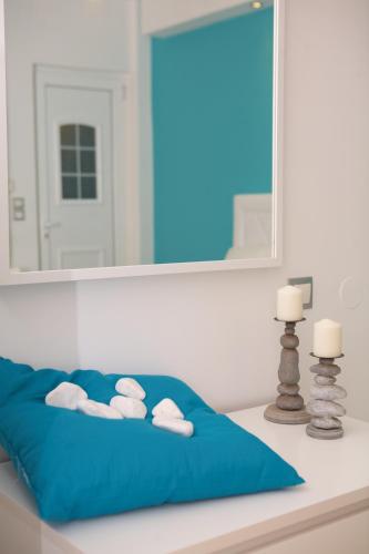 a bed with a blue pillow and a mirror at Ammos Beach in Glífa