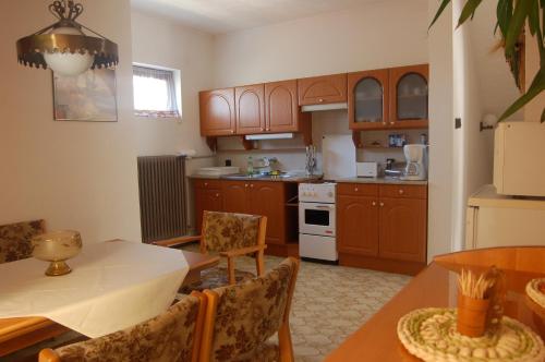 切爾塞格托毛伊的住宿－Szalai Vendégház，厨房配有木制橱柜和桌椅