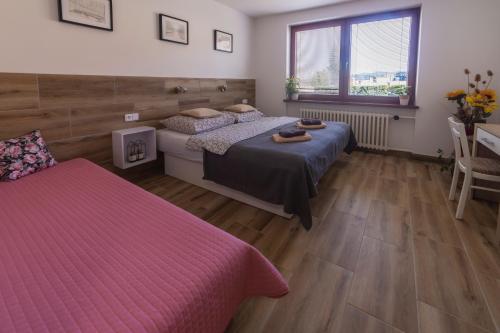 1 dormitorio con 2 camas, escritorio y ventana en Ubytování U Vávrů, en Jižná