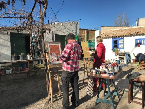 a man and a woman are painting in a yard at El Carmen in Ribera Alta