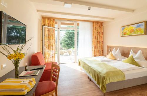 ein Hotelzimmer mit einem Bett, einem Tisch und Stühlen in der Unterkunft Hotel Steirerrast in Kaindorf