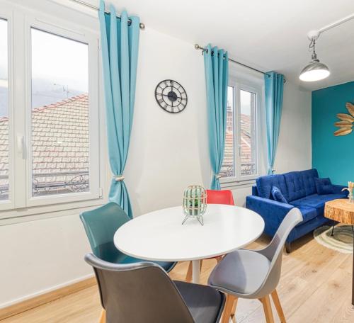 un salon avec une table et des chaises dans l'établissement Élégance contemporaine près des Thermes., à Allevard