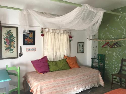 a bedroom with a bed with colorful pillows on it at El Carmen in Ribera Alta