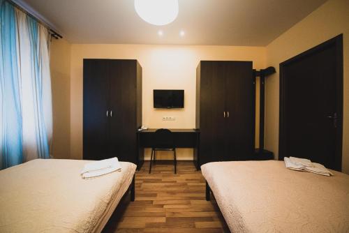 a hotel room with two beds and a desk at Kvartira Klassika na Prospekte Kultury 11 in Omsk
