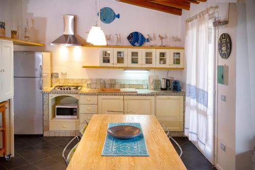 a kitchen with a wooden table with a bowl on it at Villa Isuledda Prestige in San Teodoro