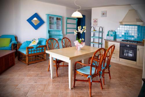 a kitchen and dining room with a table and chairs at Villa Isuledda Prestige in San Teodoro