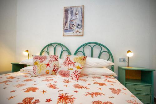 a bedroom with a bed with a green headboard and pillows at Villa Isuledda Prestige in San Teodoro