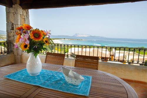 a table with a vase with a bouquet of flowers on it at Villa Isuledda Prestige in San Teodoro