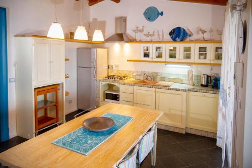 a kitchen with a wooden table with a bowl on it at Villa Isuledda Prestige in San Teodoro