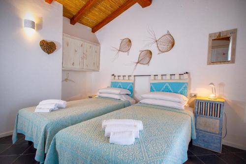 two beds in a room with blue and white at Villa Isuledda Prestige in San Teodoro