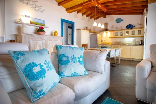 a living room with a white couch and a kitchen at Villa Isuledda Prestige in San Teodoro