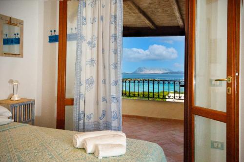 a bedroom with a window with a view of the ocean at Villa Isuledda Prestige in San Teodoro