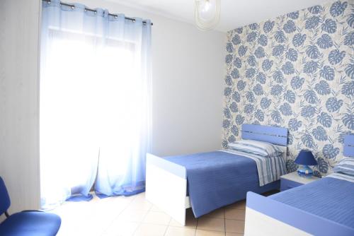 a bedroom with two beds and a window at Fornillo 41 in Poggiomarino