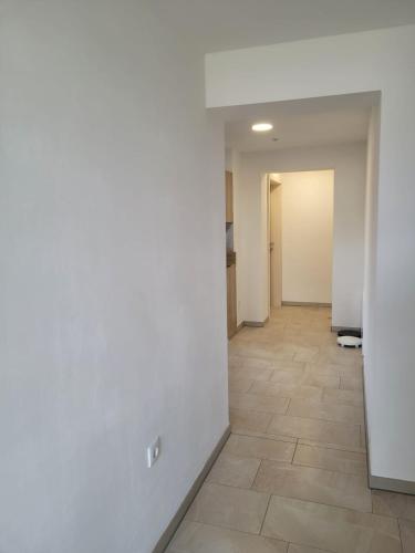 an empty hallway with a tile floor and white walls at Ferienwohnung Stoisser in Mureck