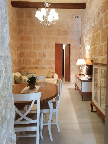 a dining room with a table and a couch at Tal-Kampjin in Mellieħa