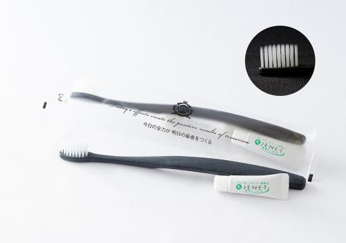 a toothbrush and a toothpaste tube on a white background at APA Hotel Kokuraeki Shinkansenguchi in Kitakyushu