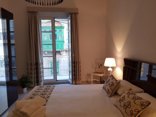 a bedroom with a bed and a large window at Tal-Kampjin in Mellieħa