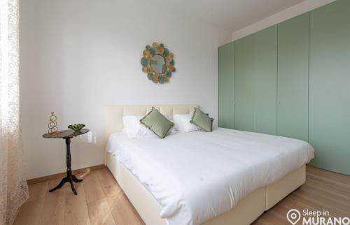 a bedroom with a large white bed and a table at The VIEW Apartment, MURANO island in Murano