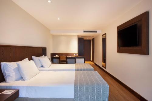a hotel room with a bed and a table at Windsor Palace Copacabana in Rio de Janeiro