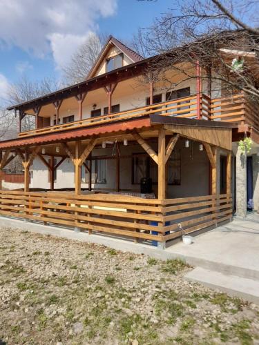 a large wooden house with a large porch at Pensiune Piatra Mare in Nehoiu