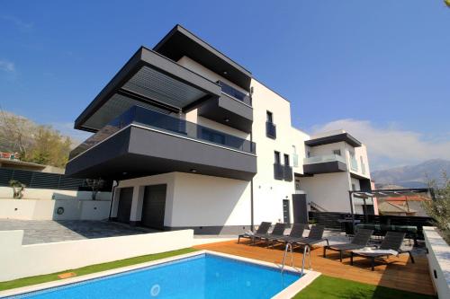 a house with a swimming pool in front of it at Villa Porta Salonae in Solin