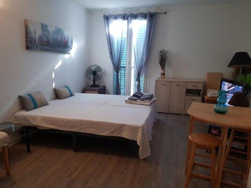 une chambre avec un lit dans une pièce avec une table dans l'établissement AJACCIO CENTRE VIEILLE VILLE IMPÉRIALE TT CONFORT TTES COMMODITÉS 3 a 4 PERs CATHÉDRALE A 300M MER PORT MARCHE LOCAL PLAGES, à Ajaccio