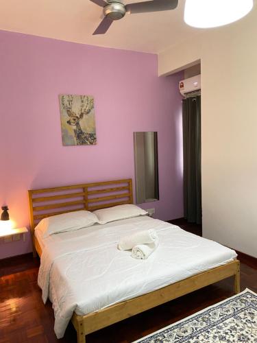 um quarto com uma cama grande e paredes roxas em Spanish Villa homestay em Senawang