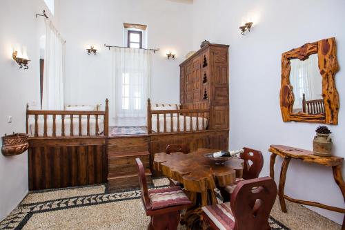 a dining room with a wooden table and a mirror at Heritage Luxury Suites in Lindos