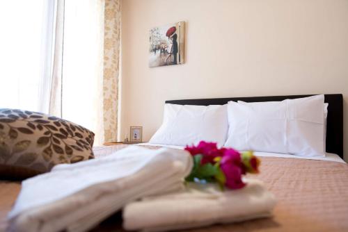 ein Schlafzimmer mit einem Bett mit Handtüchern und Blumen darauf in der Unterkunft Pura Vida Home in Laganas