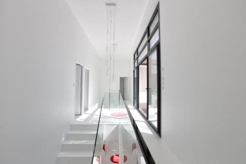 a glass staircase in a white building with a red object at HOUSE ZYX in Le Touquet-Paris-Plage