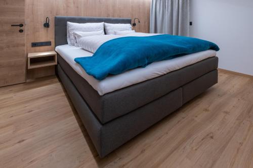 a bed with a blue blanket on top of it at Apartment Haus Schönwies in Alpbach