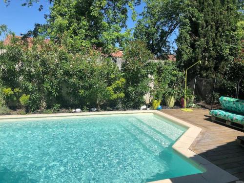 una gran piscina con un sofá azul al lado en Villa avec piscine privée au calme dans Toulouse, en Toulouse
