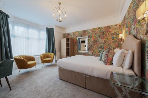 a bedroom with a large bed and a chandelier at Florence Gardens Boutique Hotel and Restaurant in Portsmouth