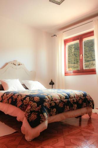 a bedroom with a bed with a floral bedspread at Blanca Martín in Trevélez