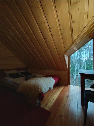 a bed in a room with a wooden ceiling at Dom Suwalszczyzna in Suwałki