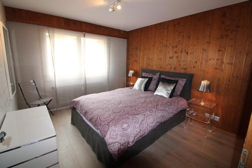 - une chambre avec un grand lit et des murs en bois dans l'établissement Mondzeu C261, à Bagnes