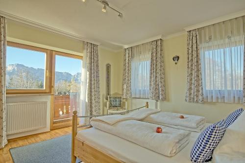 a bedroom with two beds and a large window at Ferienwohnungen Gästehaus Lärcheck in Berchtesgaden