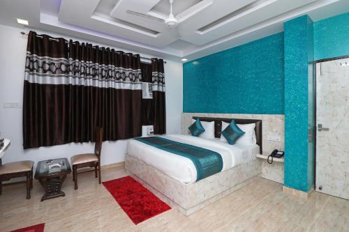 1 dormitorio con cama y pared azul en Hotel Airlift INN at Delhi Airport, en Nueva Delhi