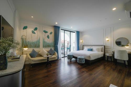 um quarto de hotel com uma cama e uma sala de estar em Lion King Hotel em Hoi An