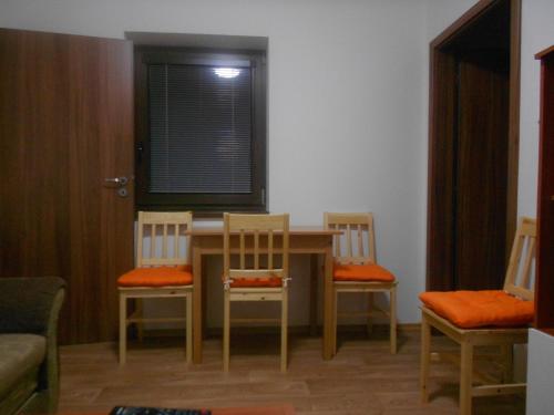 a dining room with a table and chairs and a window at Apartmán u Hovorků in Borová Lada