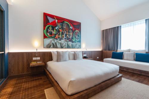 a bedroom with a large white bed and a couch at QUU HOTEL Chiang Mai in Chiang Mai