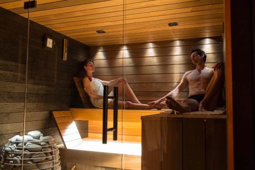 un hombre y una mujer sentados en una sauna en Gîtes de La Vesée, en La Chapelle dʼArmentières
