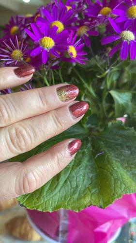 a hand with red nail polish and a vase of flowers at da Lilia in Salute&Bellezza in Monfalcone