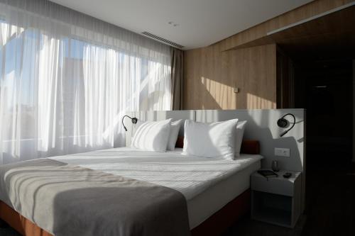 A bed or beds in a room at Premier Hotel Miskolc