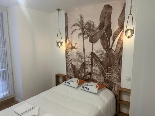 a bedroom with a bed with a mural of palm trees at Appartement Luxe Jaune in Saint Etienne