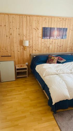 ein Schlafzimmer mit einem Bett und einem Nachttisch mit einer Lampe in der Unterkunft appartamento dario in Bodensdorf