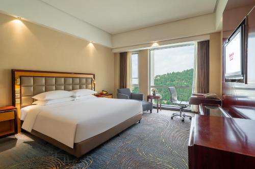 ein Hotelzimmer mit einem Bett und einem Schreibtisch in der Unterkunft Ramada Plaza Taian in Tai'an
