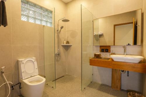 a bathroom with a toilet and a sink and a shower at boutique villa jogja senang in Yogyakarta