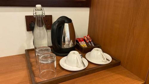 a tray with a tea kettle and glasses on a table at Beach Walk Villa Maldives in Gulhi
