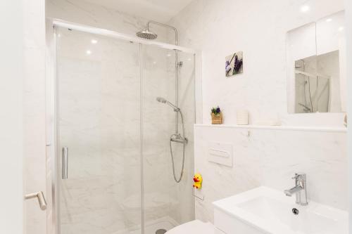 a white bathroom with a shower and a sink at FLH Marquês Charming Flats in Lisbon